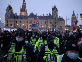 Police officers walk away from demonstrators during a protest by truck drivers over pandemic health rules and the Trudeau government, outside Parliament on Friday.