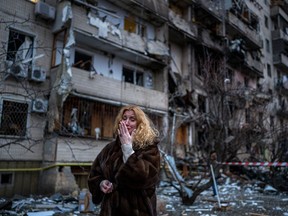 Natali Sevriukova reacts next to her home following a rocket attack the city of Kyiv, Ukraine, on Feb. 25, 2022.