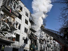 Firefighters work on a fire at a building after Russian bombings on the eastern Ukraine town of Chuguiv on Feb. 24, 2022.