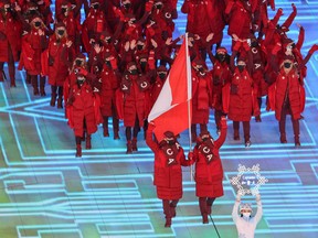 Flag-bearers Charles Hamelin and Marie-Philip Poulin lead Team Canada into the opening ceremonies of the Beijing 2022 Winter Olympics on Friday, February 4, 2022.