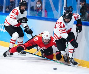 Melodie Daoust and Natalie Spooner of Team Canada clear the puck away from Stefanie Wetli of Switzerland in the hockey semifinals at the Beijing 2022 Olympic Winter Games on Monday Feb. 14, 2022. Canada won 10- 2 and is playing for a gold medal.