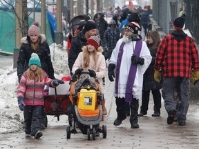 A person carries a fuel can in a stroller as truckers and their supporters continue to protest in Ottawa, Ontario, February 8, 2022. REUTERS/Patrick Doyle