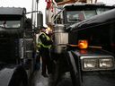 Ein Polizist steigt am Donnerstag in Ottawa auf den Beifahrersitz eines hupenden Lastwagens. 