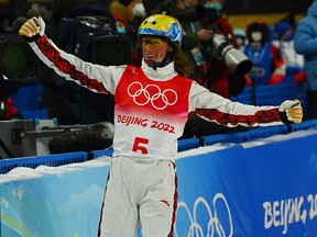 Miha Fontaine of Canada reacts after his jump in the freestyle skiing mixed team aerials.
