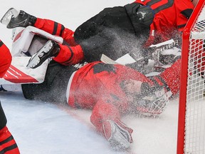 Team Canada’s goalie Eddie Pasquale gets his helmet knocked off in a collision during game action with the USA at the Beijing 2022 Winter Olympics.