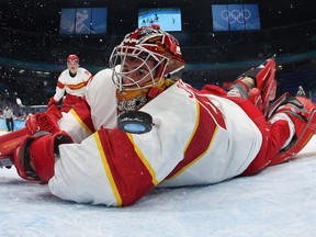 USA's Brian O'Neill (out of frame) scores a goal past China's goaltender Shimisi Jieruimi during their men's preliminary round group A match of the Beijing 2022 Winter Olympic Games.