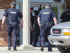 Police enter the Church of God Restoration in Aylmer, Ont., on May 14, 2021, after a judge ordered the doors padlocked to prevent church gatherings.  The Church of God and Waterloo's Trinity Bible Chapel are arguing in the Ontario Superior Court that they shouldn’t be fined for violating restrictions on religious gatherings that were meant to curb the transmission of COVID-19.