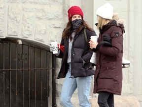Women wearing masks and carrying coffee cups on Osborne Street in Winnipeg on Sun., Jan. 17, 2021