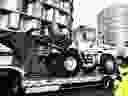 
Police officers stand next to a truck carrying a bulldozer at Porte d'Orleans in southern Paris on February 11, 2022, as convoys of protesters, inspired by Canadian truckers, are expected to arrive in the French capital.