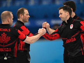 Canada's Brad Gushue  congratulates his team during the men's round robin.