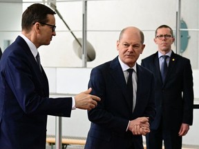 German Chancellor Olaf Scholz (C) welcomes Polish Prime Minister Mateusz Morawiecki (L) on February 26, 2022 in front of the Chancellery in Berlin for talks with the Lithuanian President, following Russia's invasion of Ukraine.  (Photo by TOBIAS SCHWARZ/AFP via Getty Images)