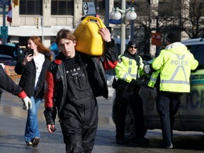 A person carries a fuel can after police said they will be targeting the truckers' fuel supply as truckers and their supporters continue to protest coronavirus disease (COVID-19) vaccine mandates, in Ottawa, Ontario, Canada, February 7, 2022. REUTERS/Patrick Doyle
