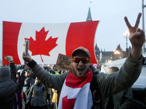 A person gives a peace sign, as truckers and supporters continue to protest coronavirus restrictions, in Ottawa, on Feb. 11.