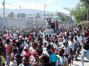 Demonstrators march during a wage protest in which a local journalist was killed, in Port-au-Prince, Haiti, on February 23, 2022.