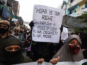 Activists from All India Majlis-E-Ittehadul Muslimeen (AIMIM) hold placards and march during a demonstration in New Delhi, on February 9, 2022 to protest after students at government-run high schools in India's Karnataka state were told not to wear hijabs in the premises of the institute.