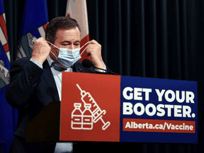 Le premier ministre de l'Alberta, Jason Kenney, enlève son masque avant de fournir une mise à jour sur le COVID-19.  Kenney dit que son gouvernement est «très impatient d'abandonner» les restrictions de santé publique.