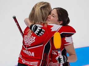 Team Canada skip Jennifer Jones gets a hug from Kaitlyn Lawes after the team won a close game against the United States 7-6 at the Beijing 2022 Winter Olympics.