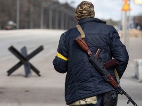 A member of the Territorial Defence Forces of Ukraine stands guard at a checkpoint on the outskirts of Kyiv, Ukraine on February 27, 2022.
