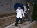 North Korean leader Kim Jong-un cautiously walks down a half-constructed staircase on a Pyongyang building site in a scene from the state media propaganda film, 2021, A Great Victorious Year.