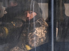 Members of Ukrainian forces looks on from a public transport bus in downtown Kyiv, on February 27, 2022.