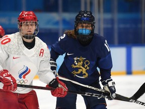 Finland's Sanni Vanhanen wears a face mask during the Tuesday game, while Anna Shibanova of the Russian Olympic Committee does not.
