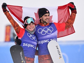 Bronze medallists Canada's Meryeta Odine and Canada's Eliot Grondin pose on the podium during the venue ceremony after the snowboard mixed team cross final during the Beijing 2022 Winter Olympic Games.