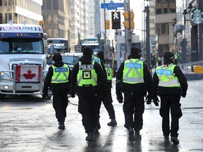 Police patrol Ottawa's Freedom Convoy blockade on Monday, which marked Day 11 of the protest.