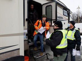 Police distribute information sheets and talk to demonstrators as truckers and supporters continue to protest coronavirus disease (COVID-19) vaccination mandates, in Ottawa, Ontario, Canada February 16, 2022. REUTERS /Blair Gable