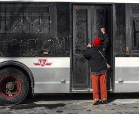 La police a utilisé des bus pour empêcher les véhicules de protestation d'atteindre les hôpitaux et le centre-ville.  Les gens ont utilisé au moins un bus pour gratter des messages dans la crasse.