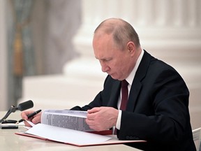 Russian President Vladimir Putin signs documents, including a decree recognising two Russian-backed breakaway regions in eastern Ukraine as independent entities, during a ceremony in Moscow, Russia, in this picture released February 21, 2022. Sputnik/Alexey Nikolsky/Kremlin via REUTERS