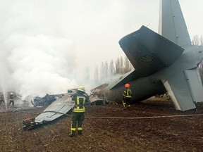 Emergency personnel work at the crash site of a Ukrainian military plane about 20 kilometres south of Kyiv amid reports of several locations around the city coming under attack in Russia's early-morning invasion of Ukraine on Feb. 24, 2022,