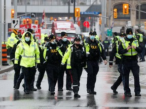 Police officers patrol on Wellington Street, in downtown Ottawa, as truckers and supporters continue to protest vaccine mandates and other measures on Feb. 17, 2022.