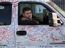 A truck driver looks out from his truck covered in support messages, as demonstrators continue to protest vaccine mandates and other COVID measures in downtown Ottawa on Feb. 7, 2022.
