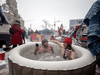 Protesters sit in a hot-tub between trucks during a protest by truck drivers COVID restrictions, near Parliament Hill in Ottawa, February 12, 2022.