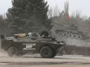 A Russian army vehicle drives past a monument displaying a Soviet-era tank, in the Crimean city of Armyansk on February 24.