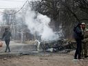 Smoke rises from a burnt car after recent shelling in the separatist-controlled city of Donetsk, Ukraine February 28, 2022.