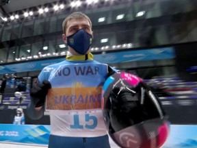 Vladyslav Heraskevych of Ukraine holds a sign with a message reading 'No war in Ukraine'