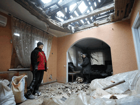 Bewohner des von der Ukraine kontrollierten Dorfes Stanytsia Luhanska beseitigen Trümmer aus ihrem Haus nach dem Beschuss durch von Russland unterstützte Separatisten am 18. Februar 2022.