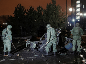 Spezialisten inspizieren ein Wrack eines Autos, das nach Angaben der örtlichen Behörden am 18. Februar 2022 in der Nähe des Regierungsgebäudes in der von Rebellen kontrollierten Stadt Donezk in der Ukraine in die Luft gesprengt wurde.