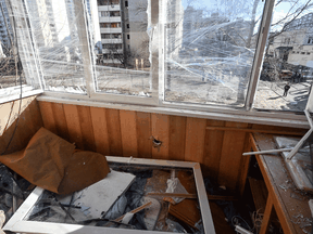 Debris and a broken window is seen in an apartment building hit by shelling in Kyiv's outskirts, February 28, 2022.