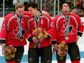Canadian Olympic Women's Hockey Team members (Left to Right) forward Stacy Wilson, defenceman Therese Brisson and forward Danielle Goyette console each other after losing to the USA 3-1 in the Gold medal game at the Olympic Games in Nagano, Japan.