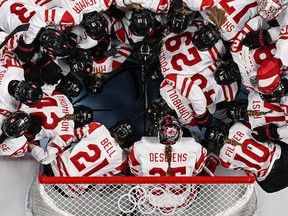 Canada's players gather before the start the women's preliminary round group A match of the Beijing 2022 Winter Olympic Games.
