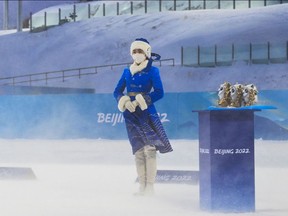 A hostess stands by ahead of the podium ceremonies for the Biathlon women’s 12.5km Mass Start event, and the Men’s 15km Mass Start event, on February 18, 2022 at the Zhangjiakou National Biathlon Centre, during the Beijing 2022 Winter Olympic Games.