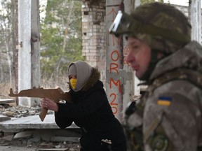Eine Frau hält eine Nachbildung eines Kalaschnikow-Gewehrs während einer Militärübung der Ukrainischen Territorialen Verteidigungskräfte, der Militärreserve der ukrainischen Streitkräfte, am 19. Februar außerhalb von Kiew.
