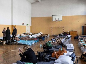Menschen werden am 26. Februar an einer provisorischen Unterkunft für ukrainische Flüchtlinge in einer Grundschule in Przemysl, Ostpolen, gesehen