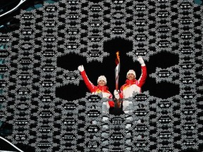 Torchbearers hold the Olympic flame during the opening ceremony of the Beijing 2022 Winter Olympic Games, at the National Stadium, known as the Bird's Nest, on Feb. 4.