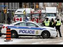La policía patrulla una barricada mientras los vehículos bloquean las calles de la ciudad mientras los camioneros y los simpatizantes protestan contra los mandatos de vacunación contra el covid-19 en Ottawa, el 3 de febrero de 2022. 