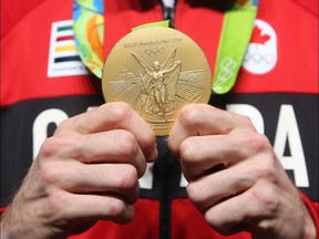 Derek Drouin, gold medalist in men's high jump, holds his gold medal after a press conference with the media at the Rio 2016 Olympics in Rio de Janeiro, 18, 2016.