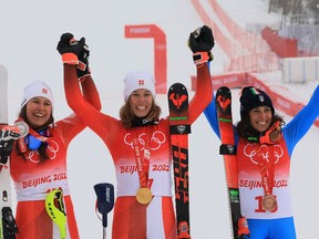 Gold medallist Michelle Gisin of Switzerland celebrates with silver medallist Wendy Holdener of Switzerland and bronze medallist Federica Brignone of Italy.