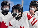 Canada's Sarah Fillier (C) and her teammates react during the ladies' preliminary group A match in the 2022 Winter Olympics.